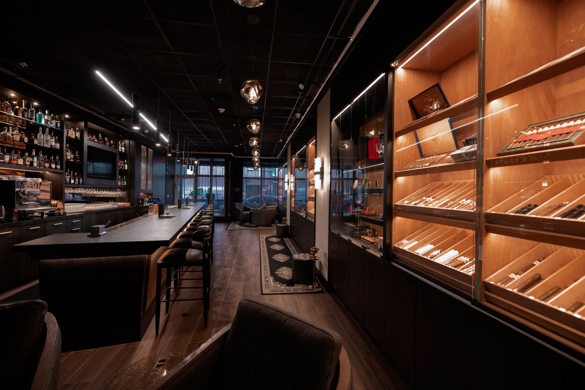 Cigar Club Miami interior with a long bar, dark stools and warmly lit display cabinets