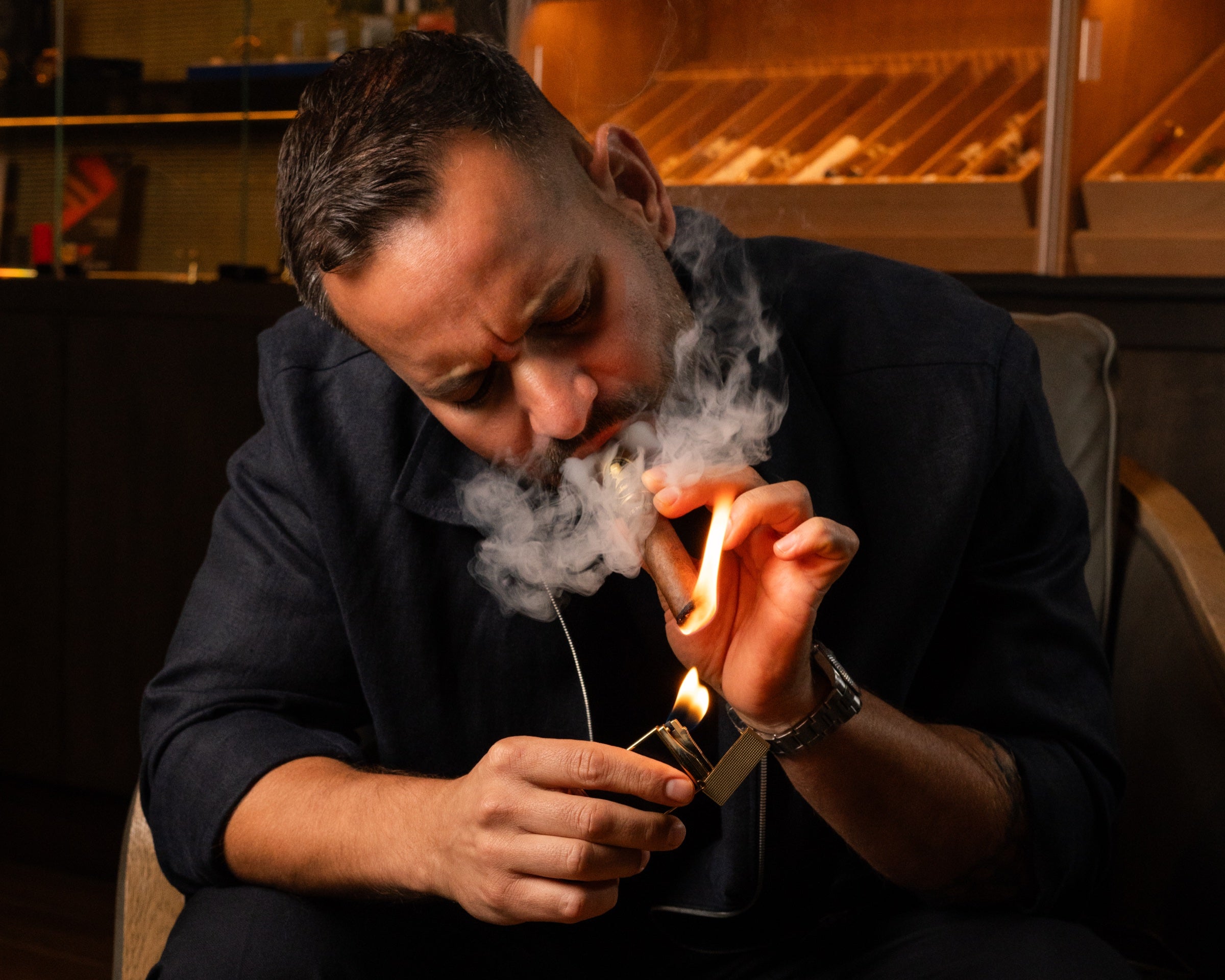 Close-up of a guest lighting a cigar with smoke at Cigar Club Miami